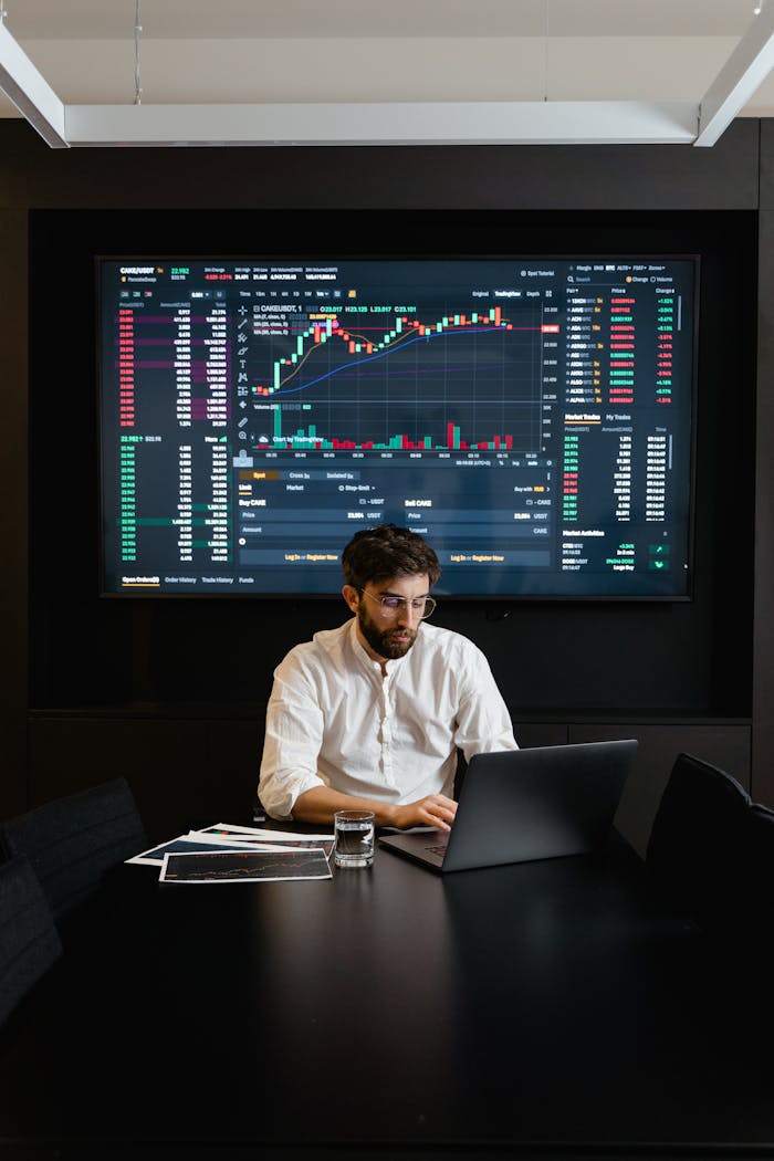 services-04 A stock trader analyzes cryptocurrency data on a laptop with graphs and charts on a screen.